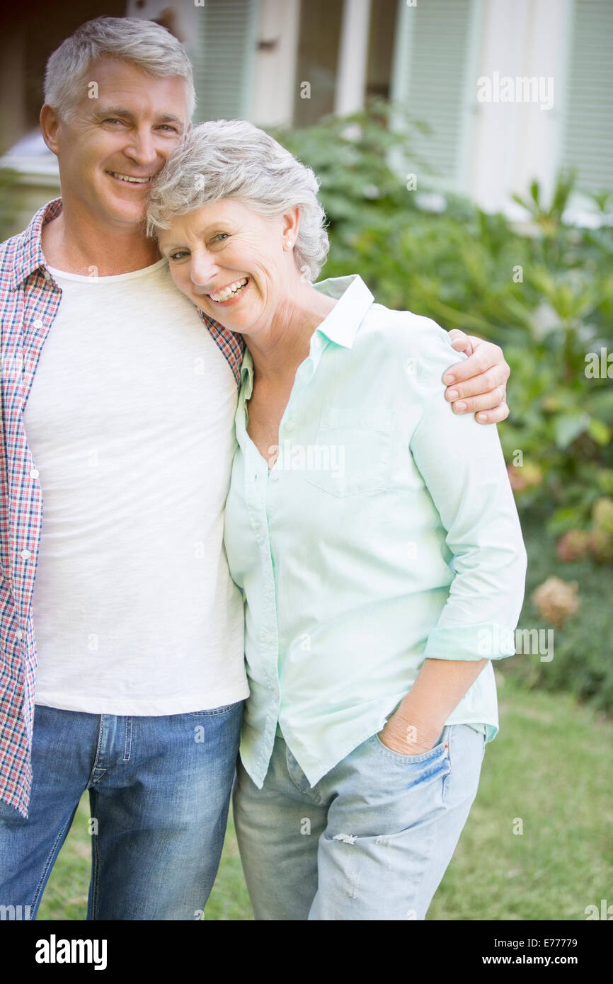 Older couple hugging outdoors Stock Photo