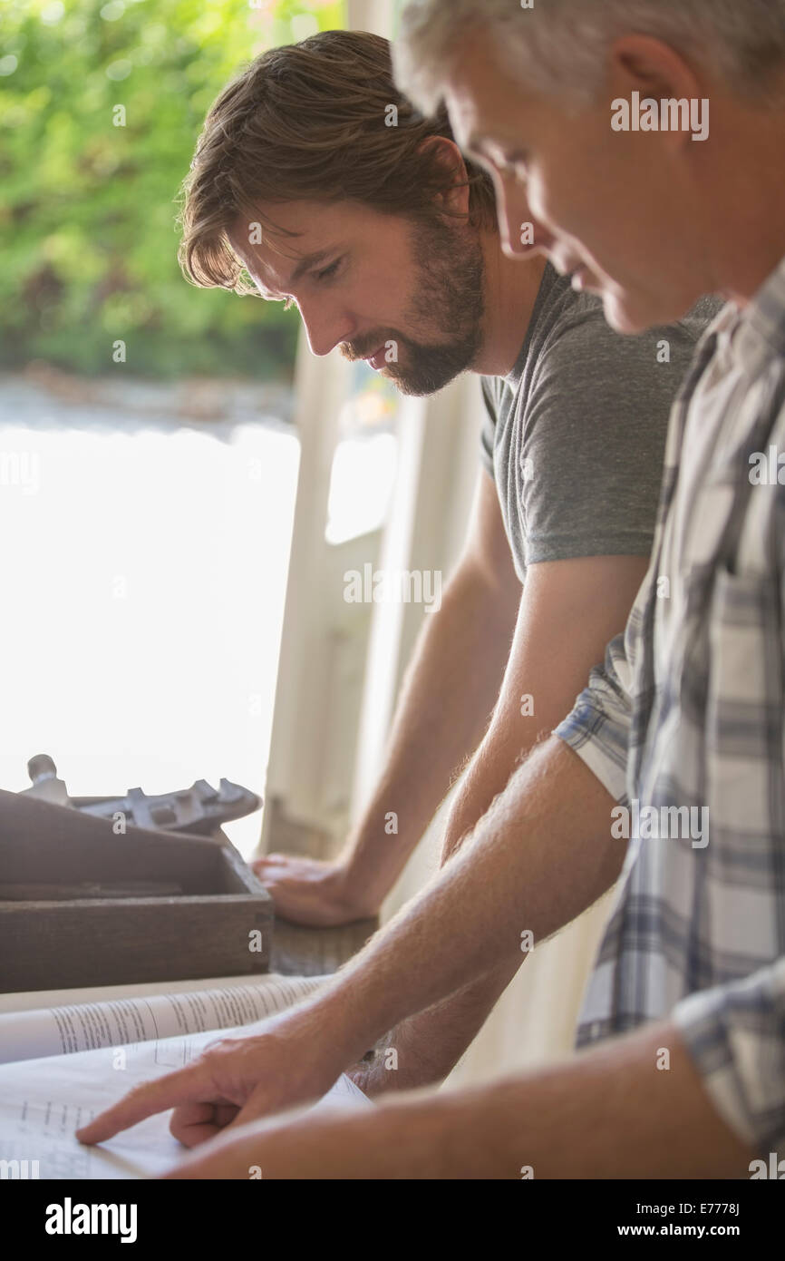 Father and son looking through documents together Stock Photo