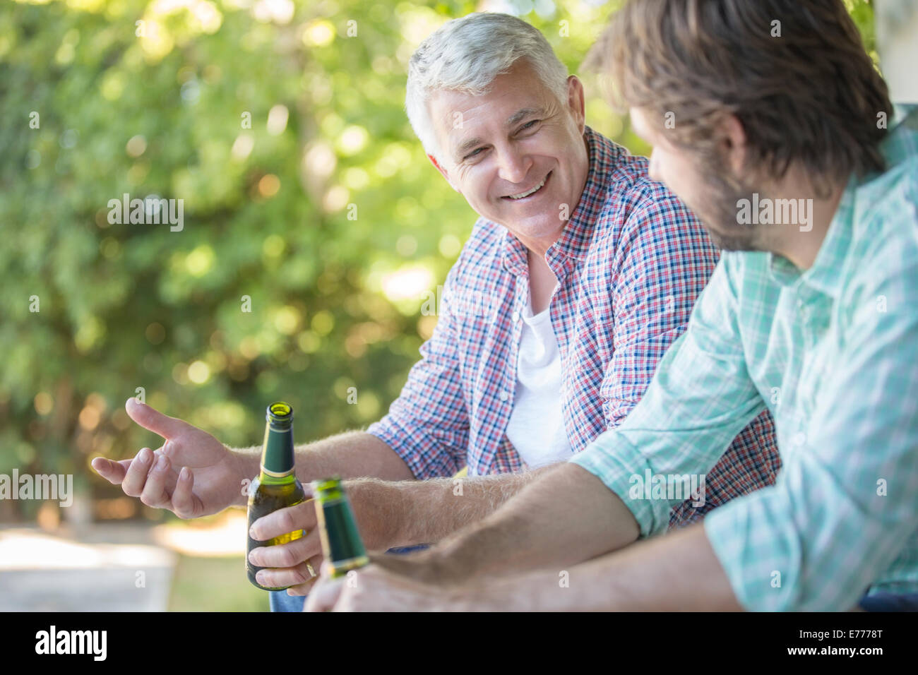 Father and son drinking outdoors Stock Photo