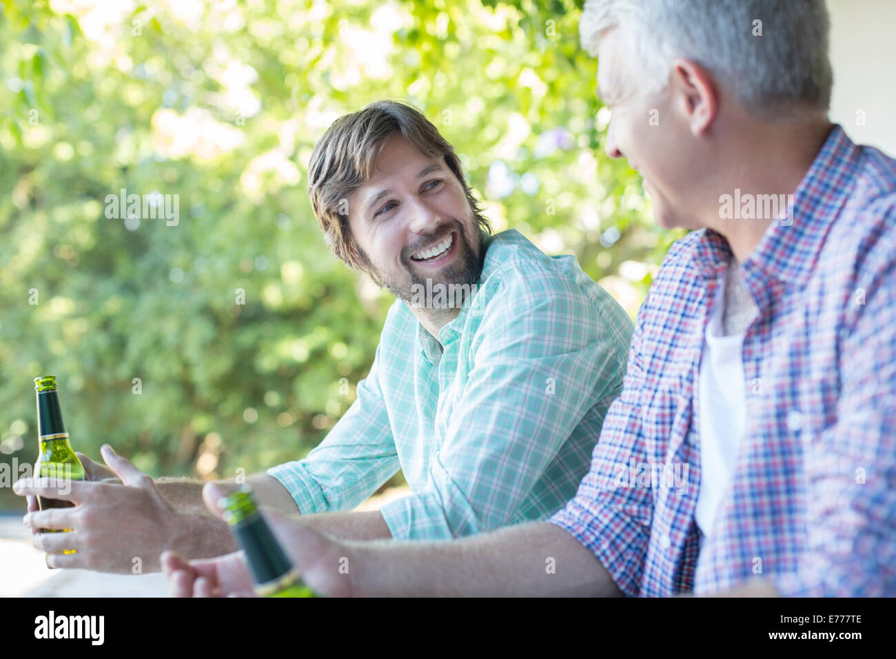 Father and son drinking outdoors Stock Photo