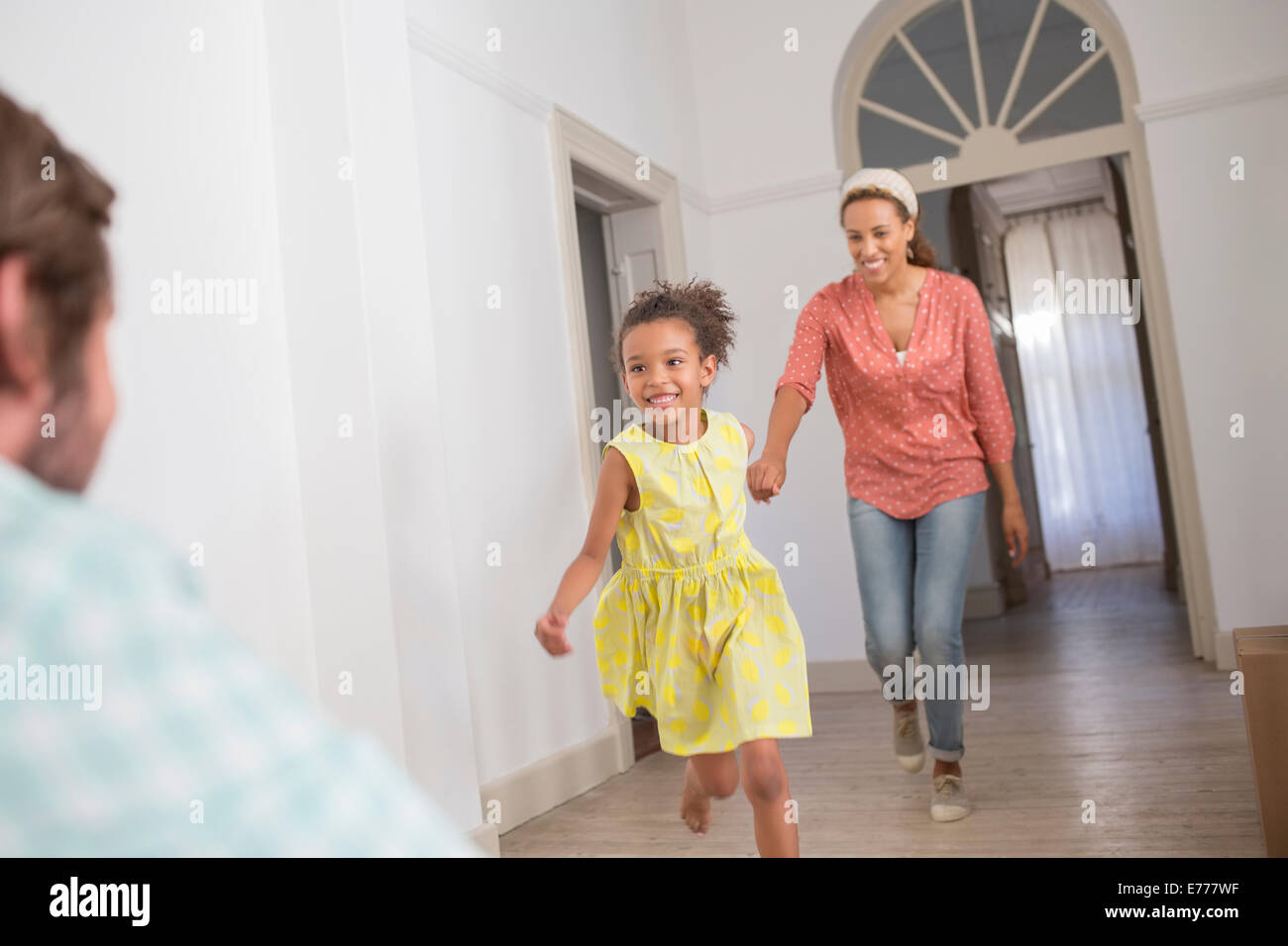 Mother and daughter running towards father Stock Photo