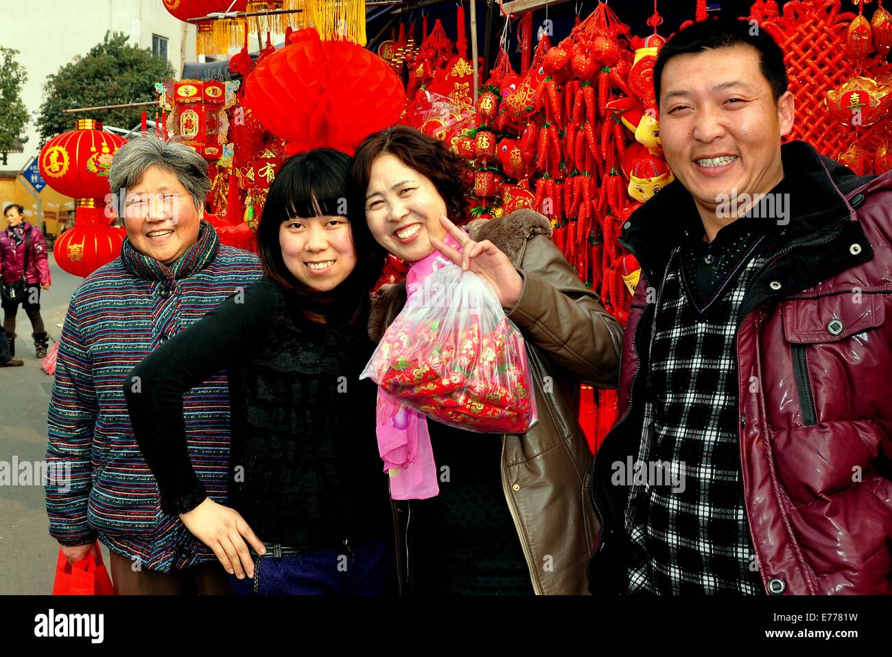 PENGZHOU, CHINA:  A family with newly purchased Chinese New Year decoration at the outdoor marketplace in Long Xing Square Stock Photo