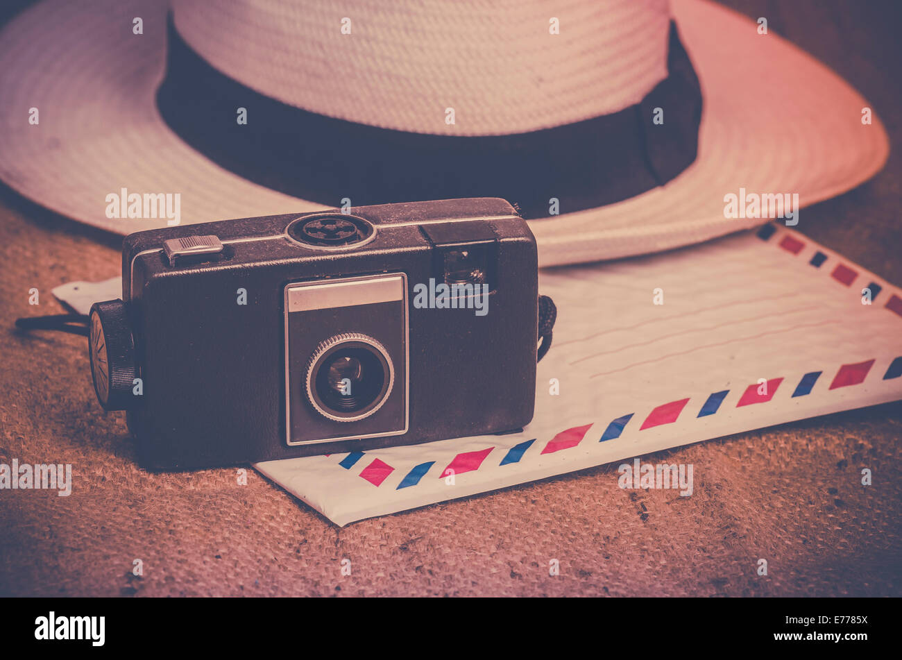 Nostalgic travel explorer concept photo, old film camera, hat and airmail letter on canvas Stock Photo