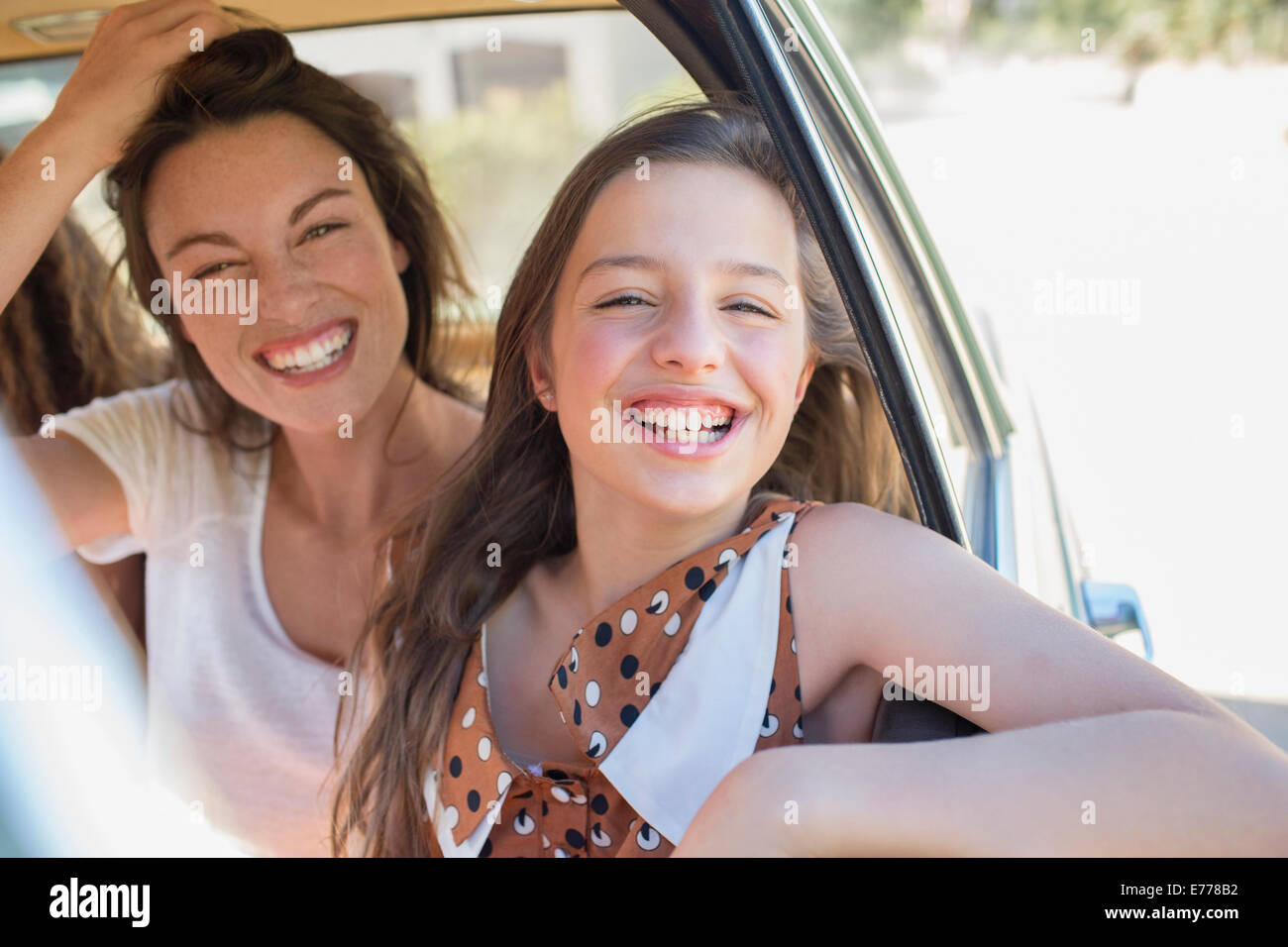 Sisters laughing in car backseat Stock Photo