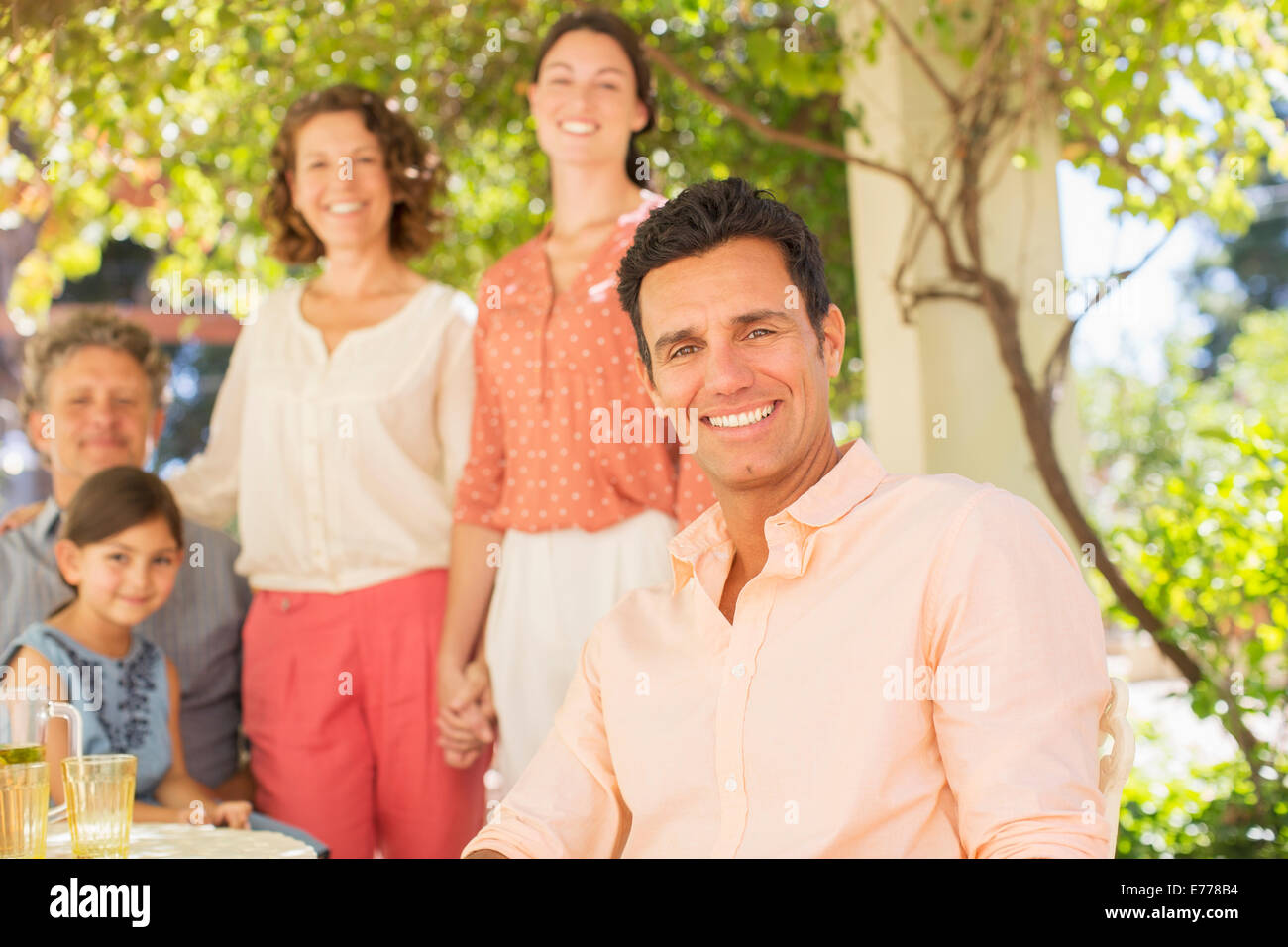 Family gathered around table outdoors Stock Photo