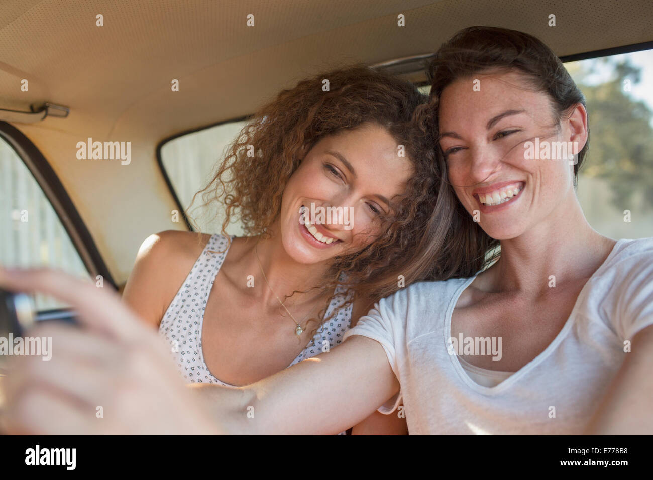 Sisters taking picture together on cell phone Stock Photo