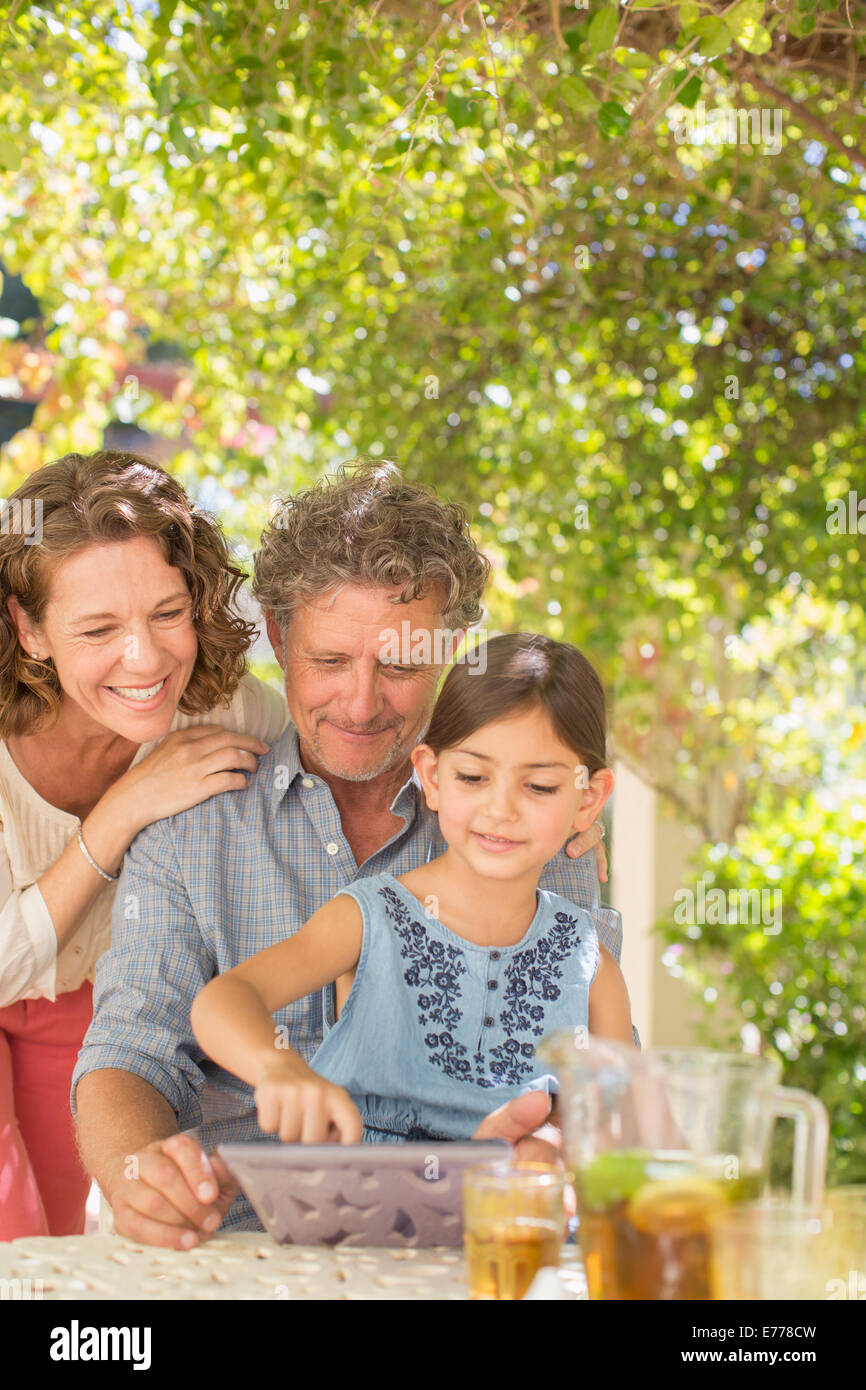 Grand parents playing on digital tablet with granddaughter Stock Photo