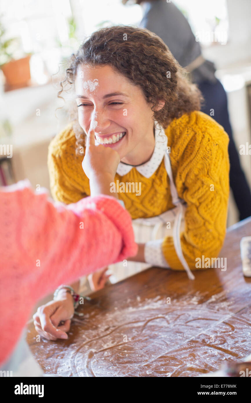 Daughter putting flour on mother’s nose Stock Photo