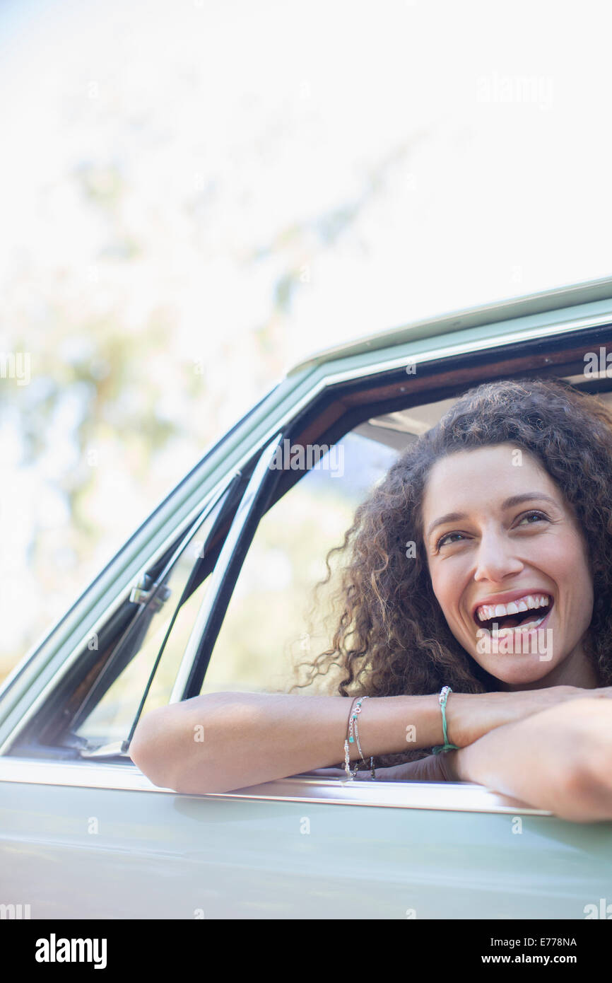 Woman relaxing on car door during car ride Stock Photo