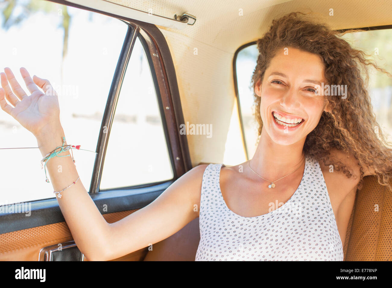 Woman feeling breeze from backseat car window Stock Photo