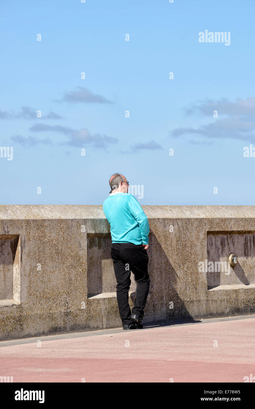 Man in bright pullover, using his mobile phone Stock Photo