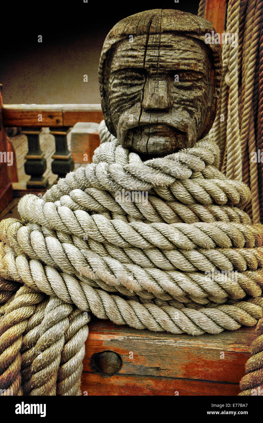 Head shaped wooden cleat on an old sailboat with ropes fastened around. Retro Istagram-like filter added. Stock Photo