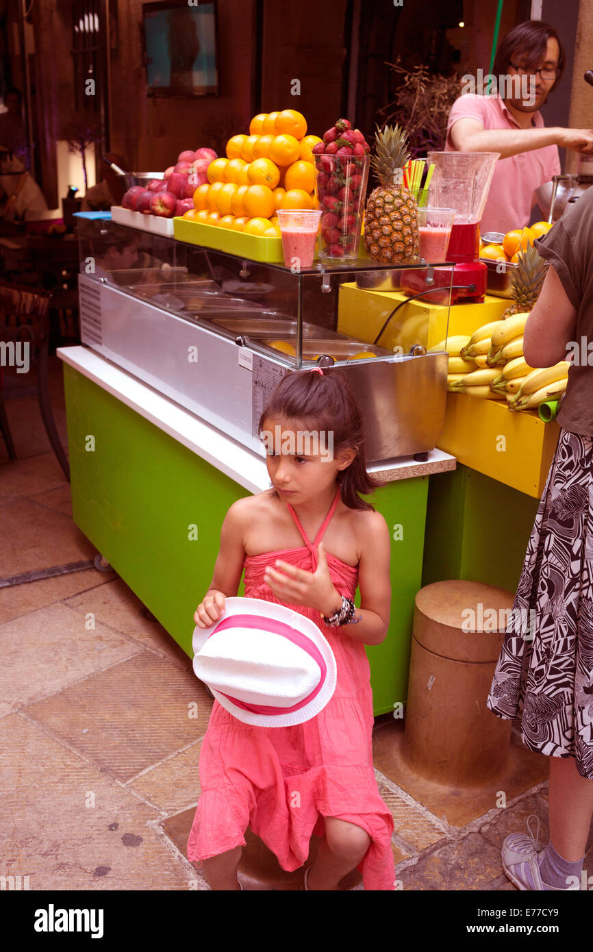 Little girl holding white straw hat in the market in Aix-en-Provence France Stock Photo
