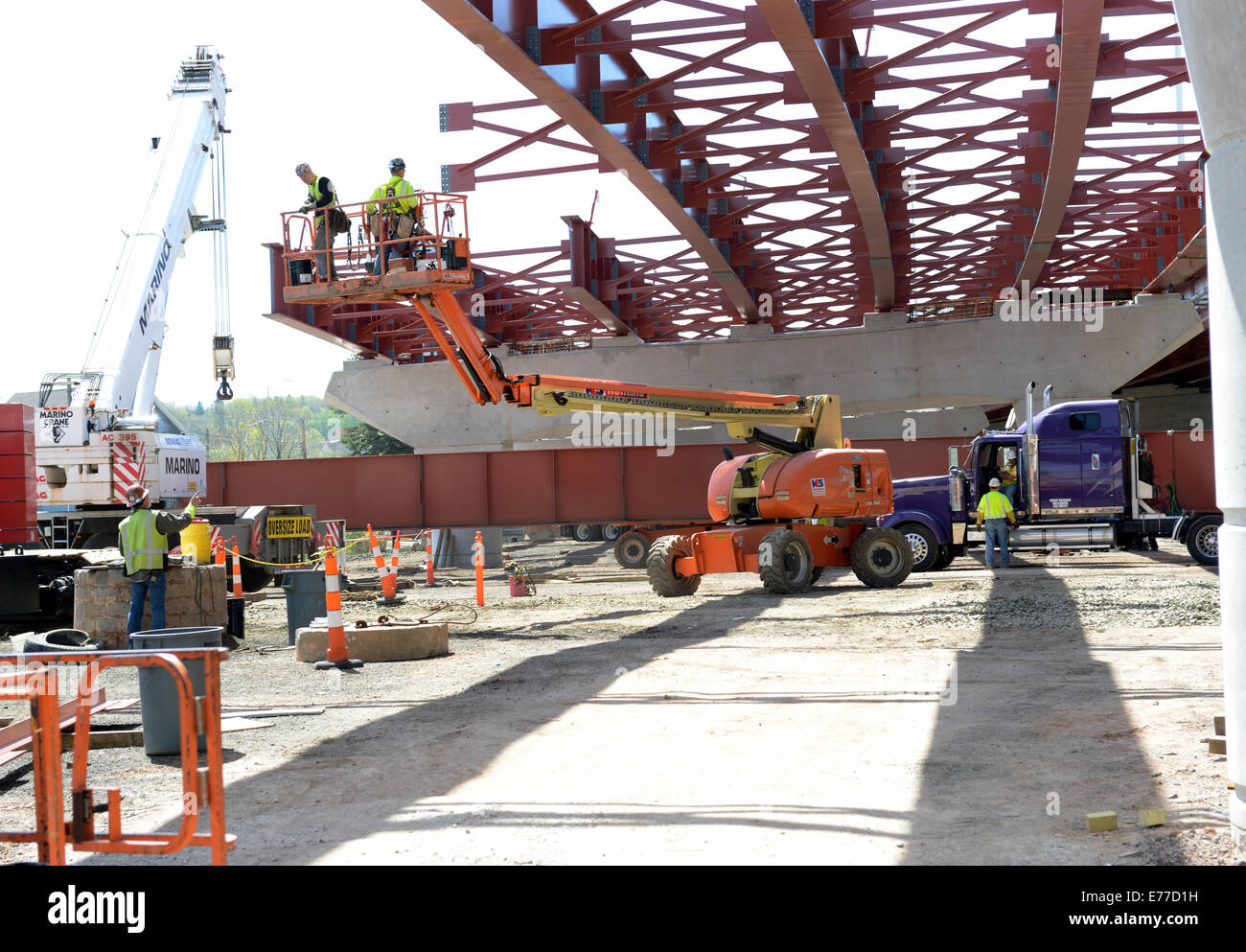 Iron Workers on a lift platform get ready to attach new steel beams for new bridge on New Haven Harbor Crossing Project. Stock Photo