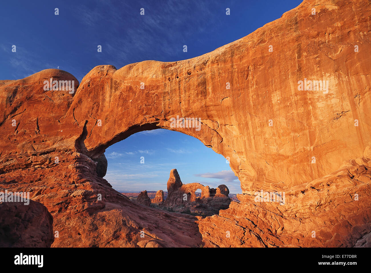 Turret Arch seen through the North Window Arch at sunrise in Arches