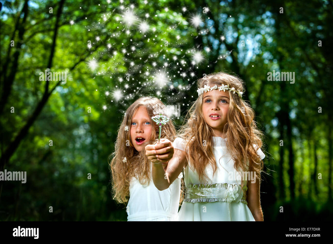 Fantasy portrait of cute girls with magic wand in forest. Stock Photo