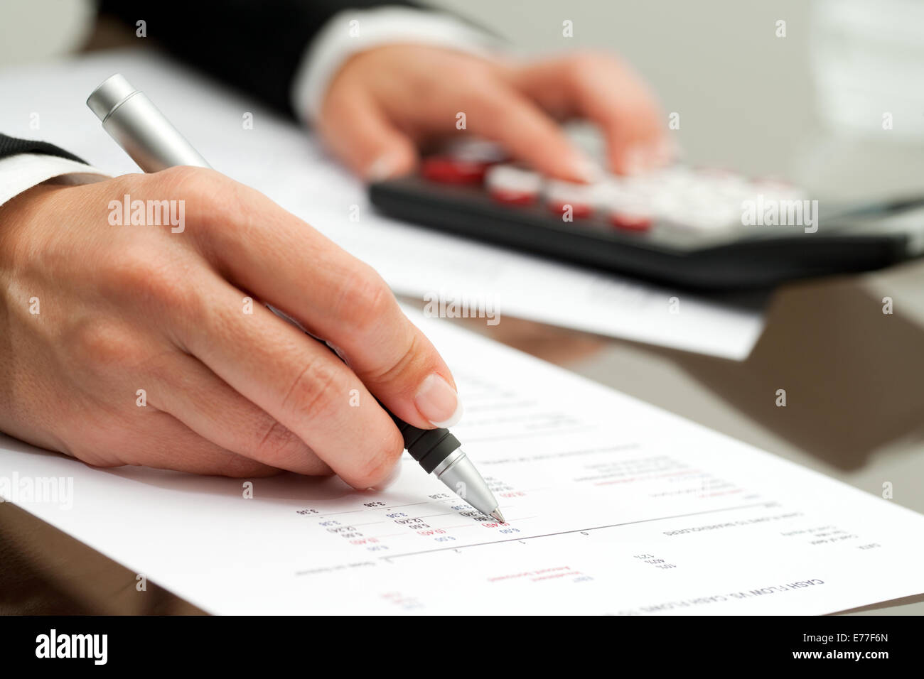Extreme Close Up Of Female Hand With Pen Pointing On Cash Flow Document 