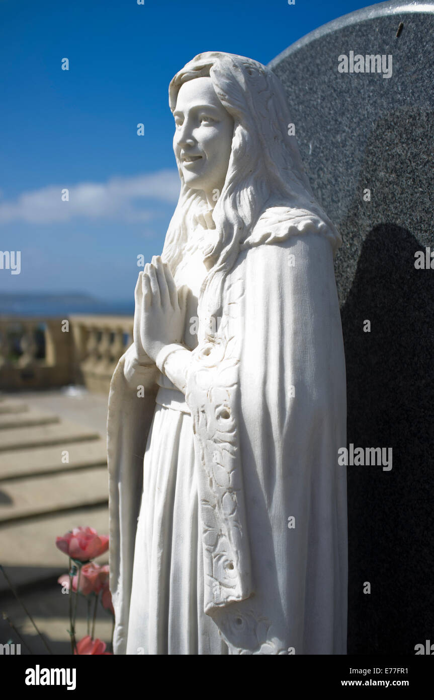 Mary mother of God statue in a graveyard. Stock Photo