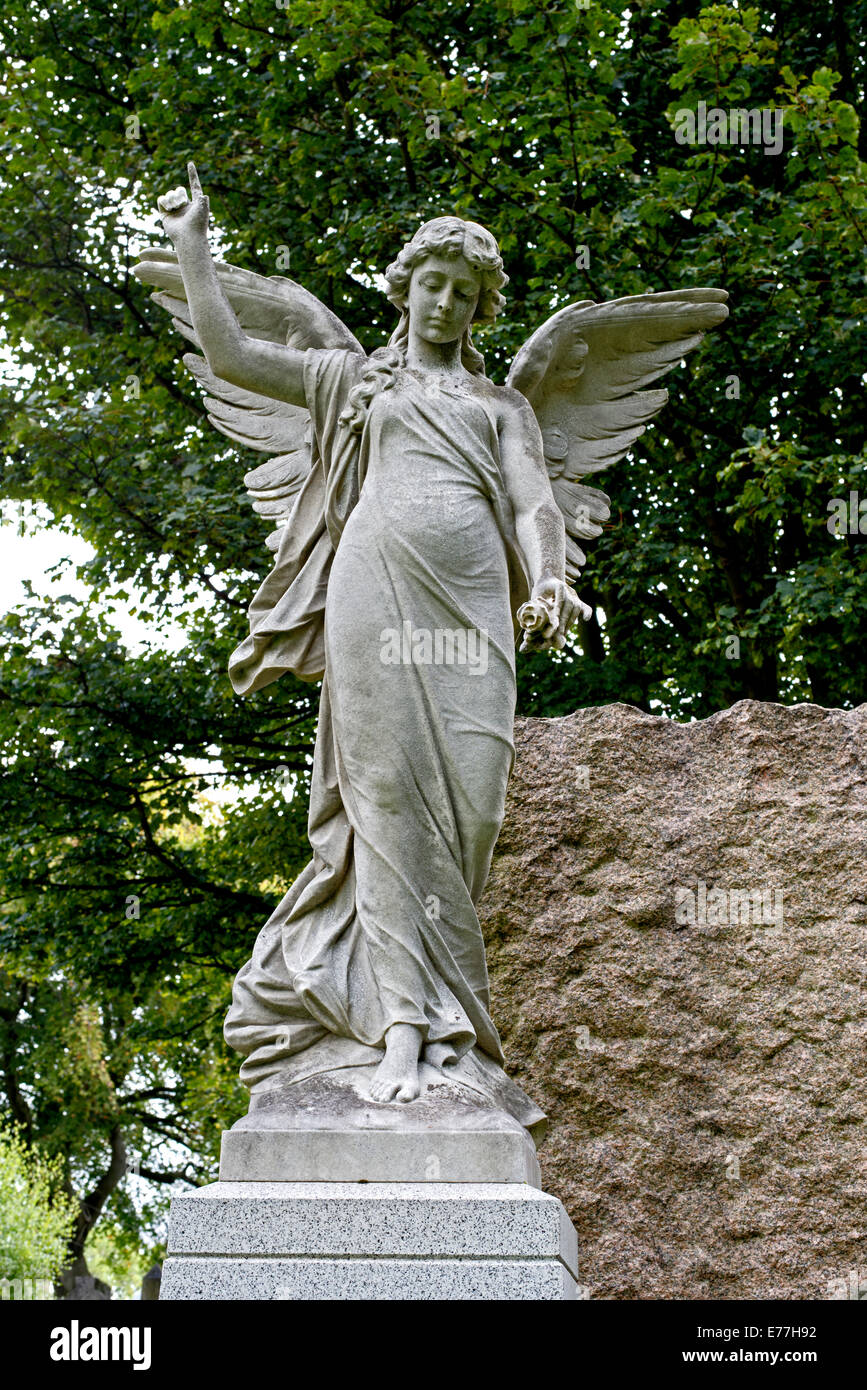 Statue of an angel holding a flower and pointing to heaven in the Grange Cemetery Edinburgh, Scotland. Stock Photo