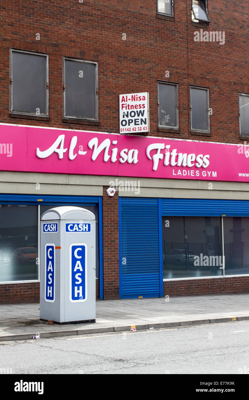 A ATM cash machine fitted into a telephone box outside Al-Nisa Fitness in Attercliffe Sheffield England UK Stock Photo