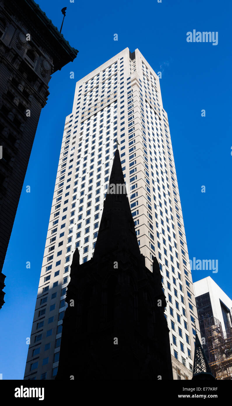 The silhouetted spire of St Patrick's Cathedral, Midtown Manhattan, New York contrasts with a modern skyscraper background Stock Photo