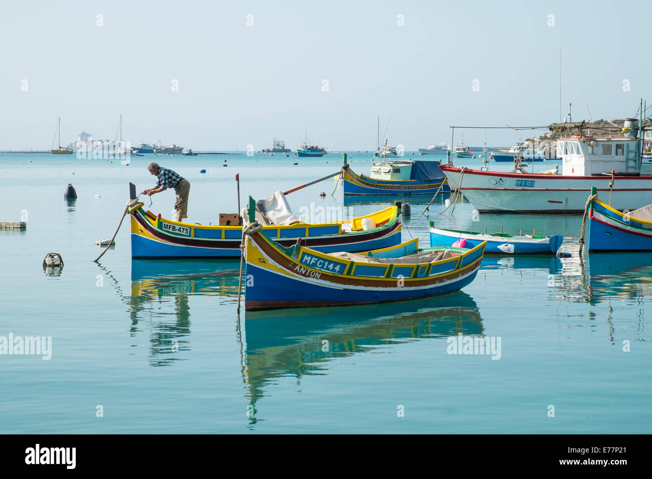 Fisherman Working On His Luzzu In The Harbor At Marsaxlokk Malta Stock Photo Alamy