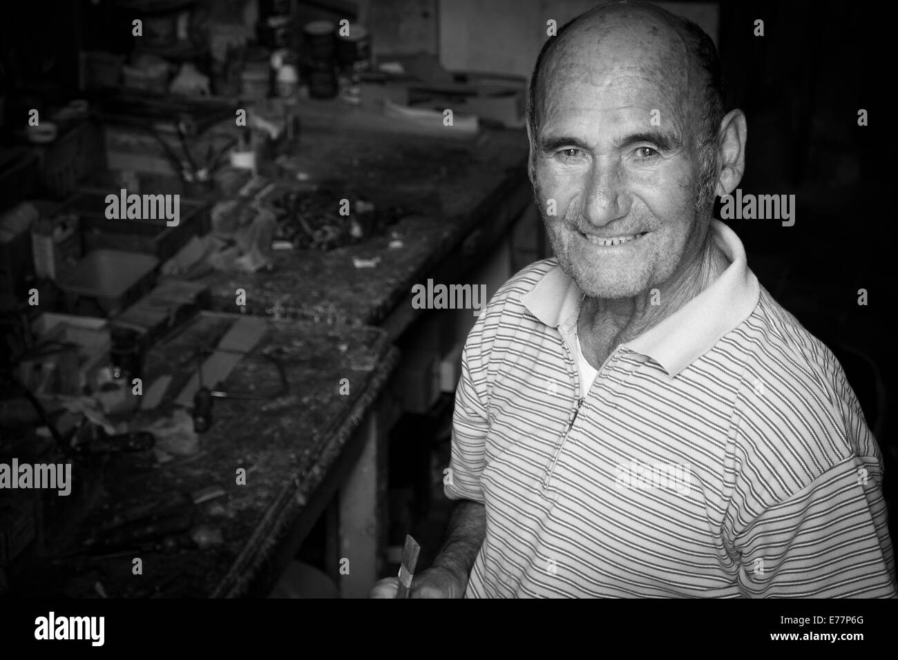 Man pictured at the entrance to his workshop where he makes model boats in Vittoriosa, Malta Stock Photo
