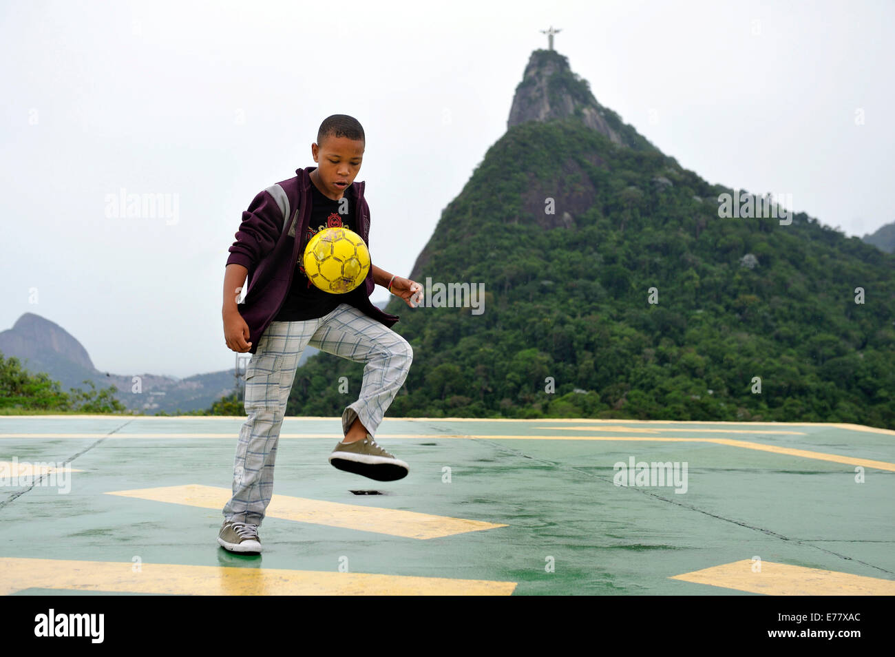 Teenager, 15 years, playing with a soccer ball, Corcovado mountain with the statue of Cristo Redentor at the back Stock Photo