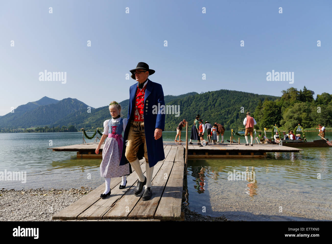 Locals wearing traditional costumes disembarking a boat at a jetty, Alt-Schlierseer-Kirchtag festival, Schliersee, Upper Bavaria Stock Photo