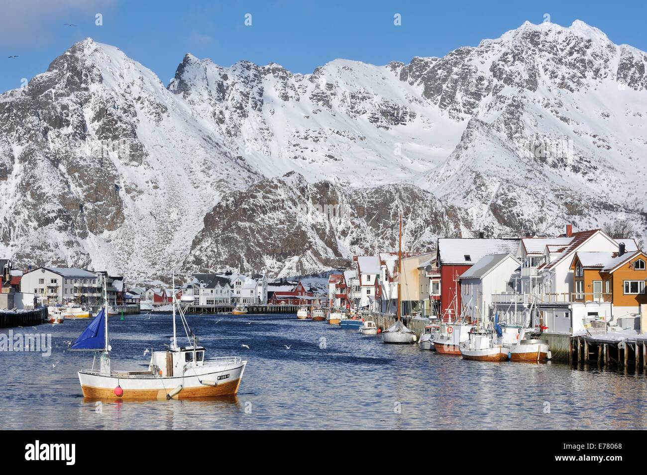 Marina and town in front of snowy mountain range. Henningsvær, Lofoten, Norway Stock Photo