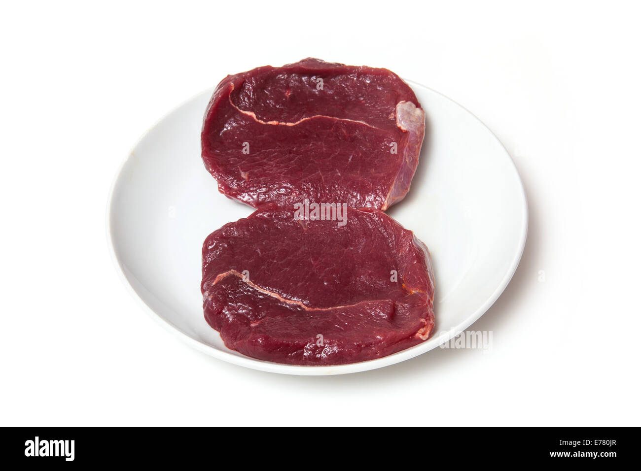 Plate of raw Zebra steaks isolated on a white studio background Stock