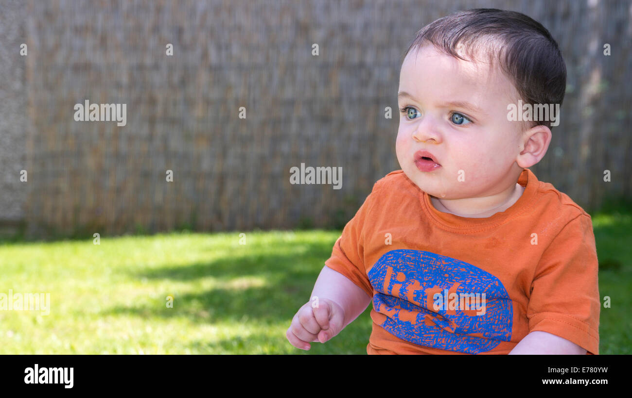 Baby contemplating looking into the distance thinking Stock Photo