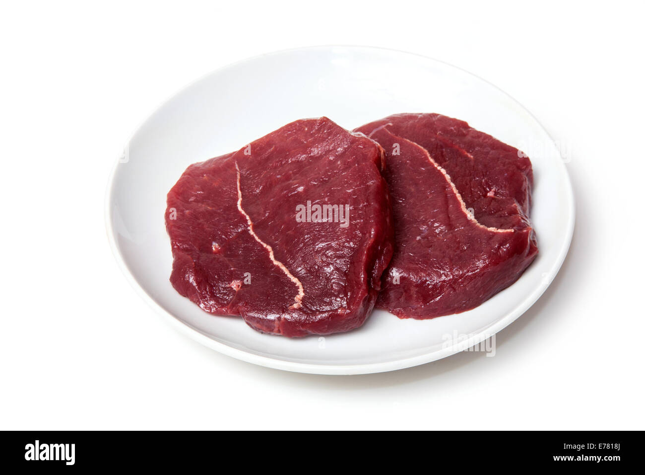 Plate of raw Zebra steaks isolated on a white studio background Stock