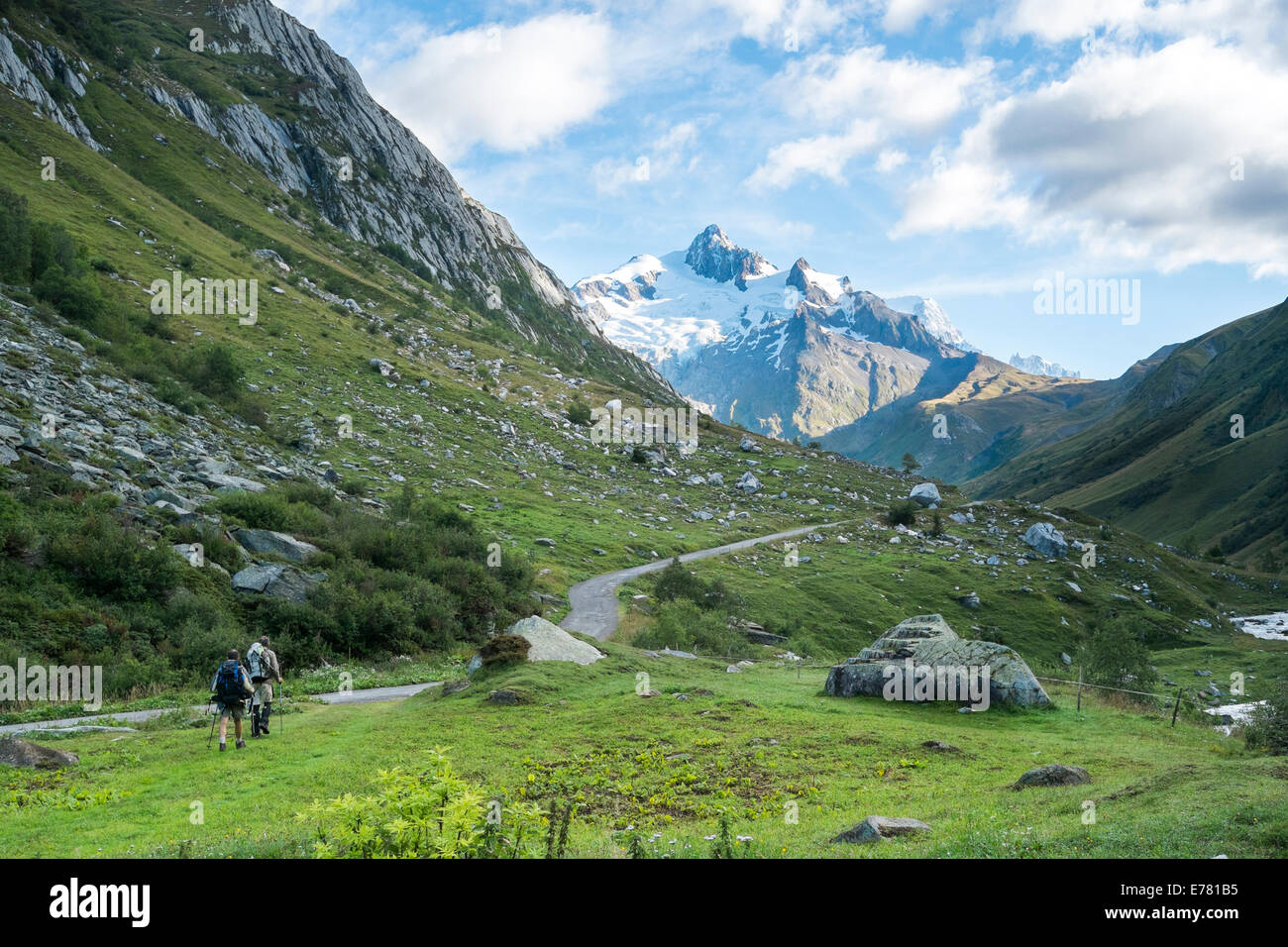 LES CHAPIEUX, FRANCE - AUGUST 27: Hikers walking with Glacier Needles in the background. The region is a stage at the Mont Blanc Stock Photo