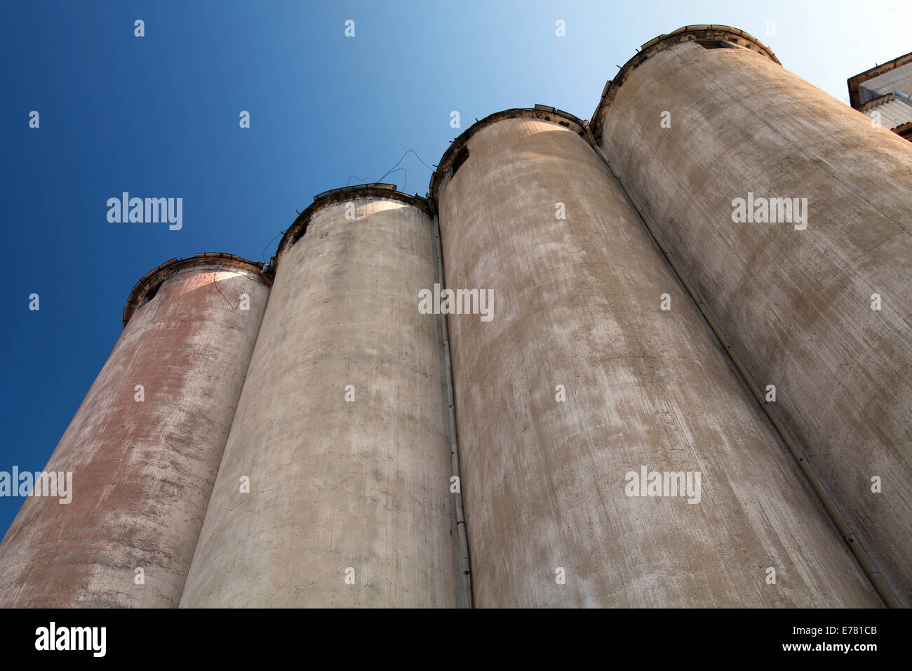 Row of grain silos under deep blue sky Stock Photo