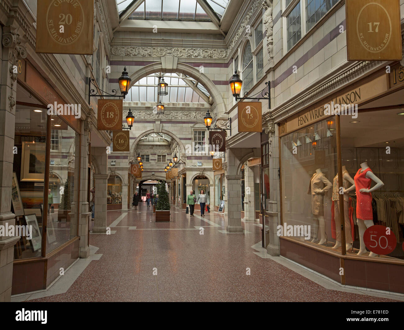 Interior of elegant and historic shopping arcade with high glass ceiling, decorative carvings on stone walls in city of Chester Stock Photo
