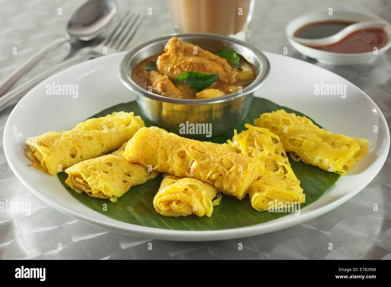Roti jala with kari ayam. Lacy pancakes with chicken curry. Malaysia Food Stock Photo