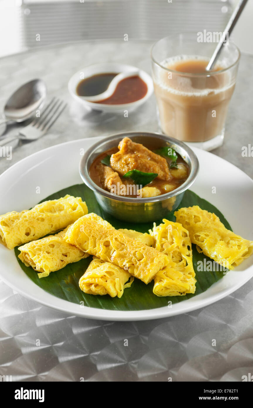 Roti jala with kari ayam. Lacy pancakes with chicken curry. Malaysia Food Stock Photo