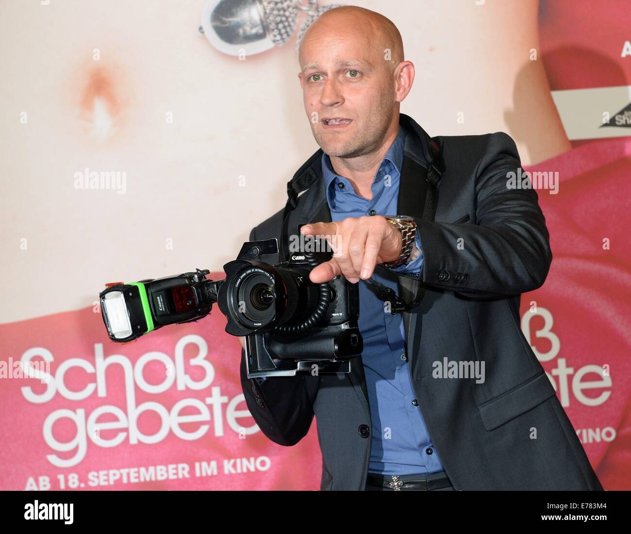 Actor Juergen Vogel takes a picture with the camera of a press photographer as arrives for the film premiere of Schossgebete in Berlin, Germany, 08 September 2014. The film will come to German cinemas on 18 September 2014. Photo: Britta Pedersen/dpa Stock Photo