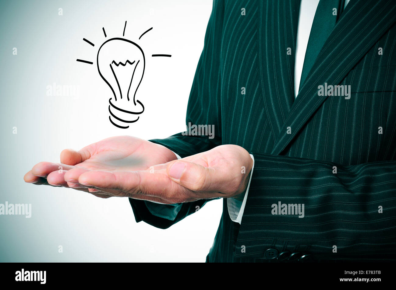 a man wearing a suit with a lightbulb drawn in his hand Stock Photo