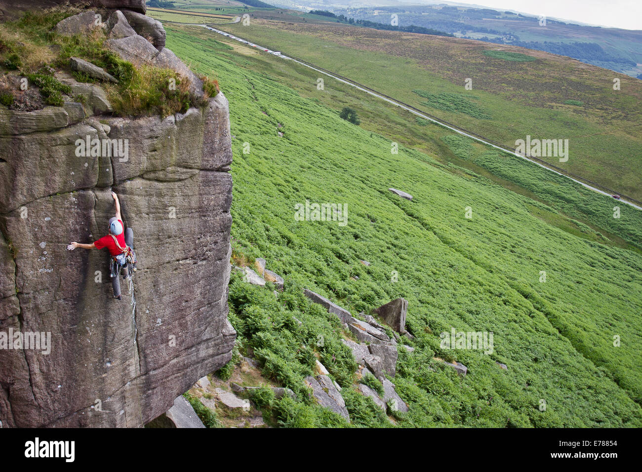 A man rock climbing at Stanage Edge nr Hathersage and Sheffield in the Peak District National Park, England UK Stock Photo