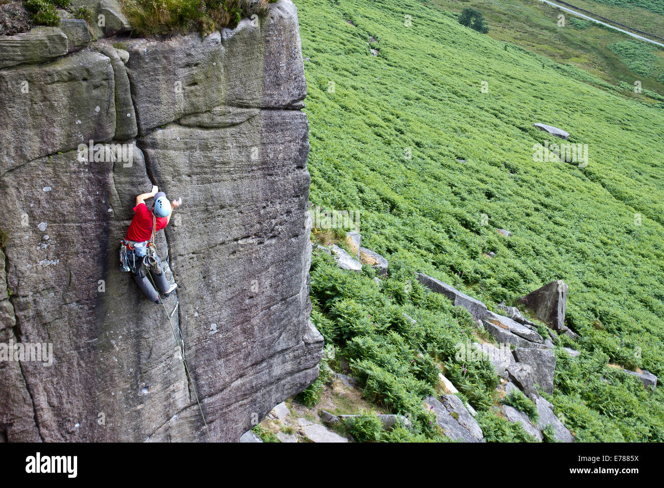 A man rock climbing at Stanage Edge nr Hathersage and Sheffield in the Peak District National Park, England UK Stock Photo