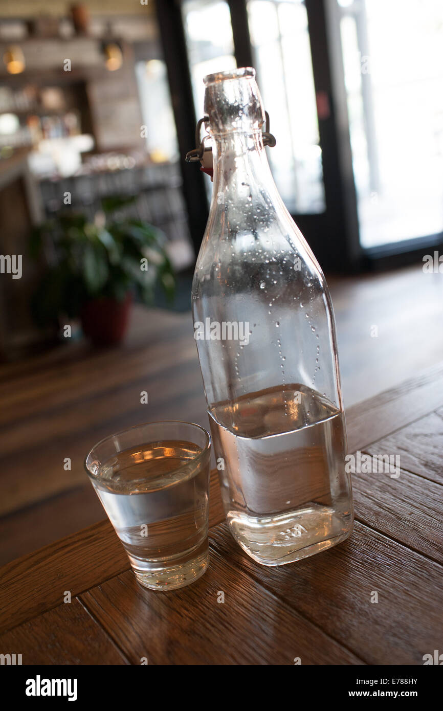 Bottle of water and glass at Bare Burger restaurant in Columbus Ohio Stock Photo