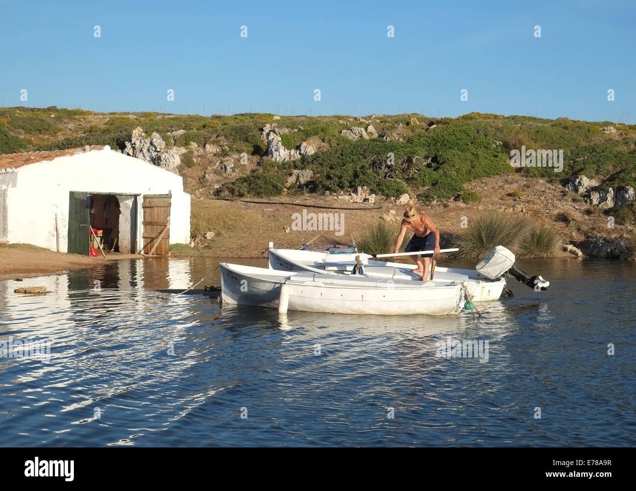 Local fisherman on his fishing boat at Sanitja, near Fornells, Menorca, Spain Stock Photo