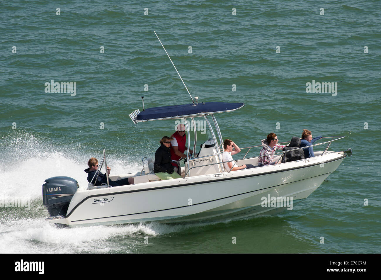 Family enjoying an afternoon out in a speedboat. Stock Photo