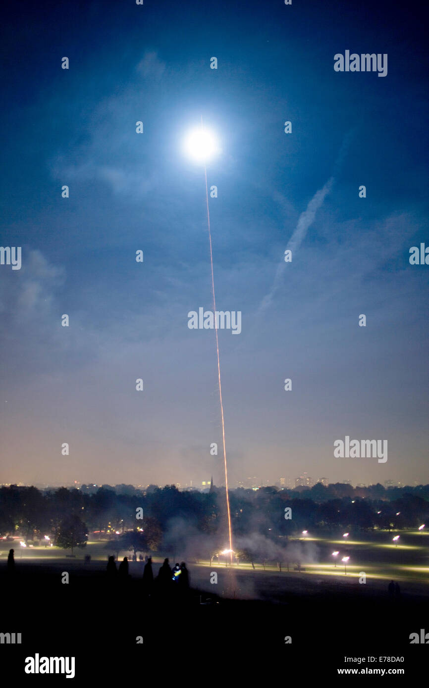 A firework rocket shoots into the night sky and explodes over Londons skyline. Stock Photo
