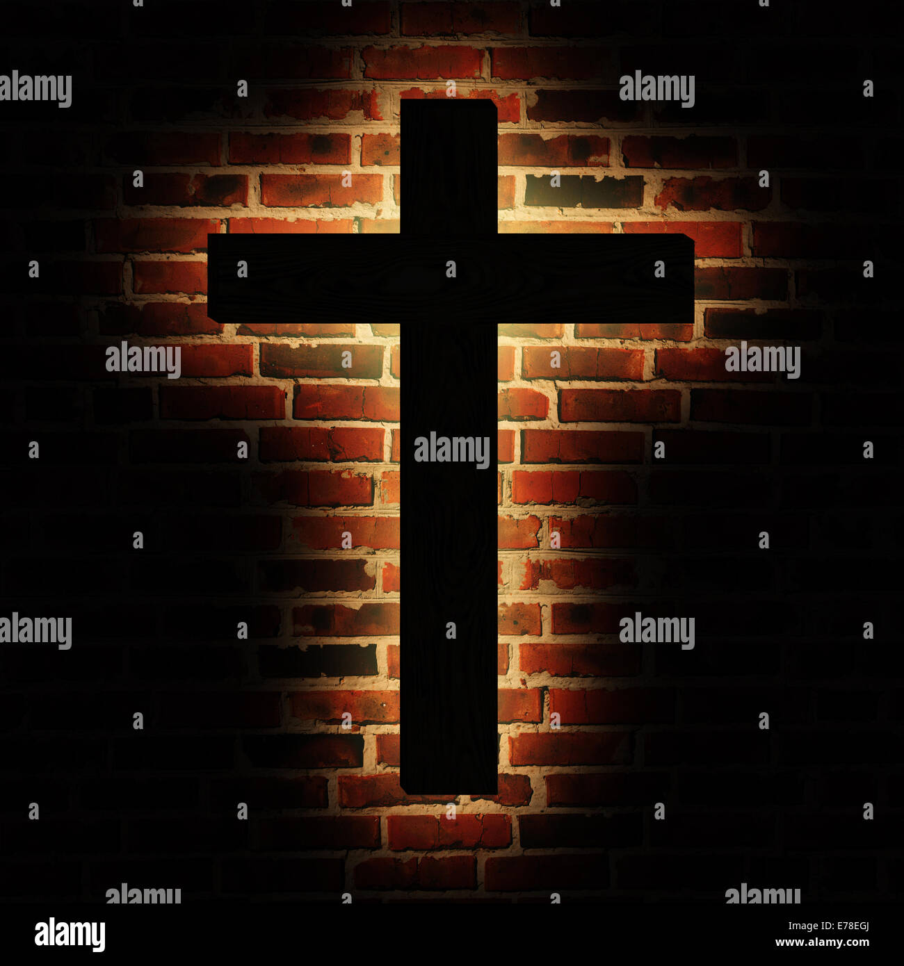 Wooden cross with the light on the brick wall Stock Photo