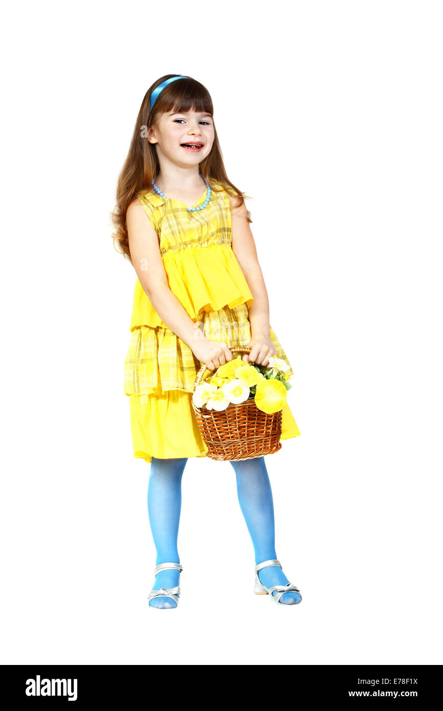 Cute little girl in yellow dress and blue with flower basket in hands looks slyly. Full height portrait isolated on white Stock Photo