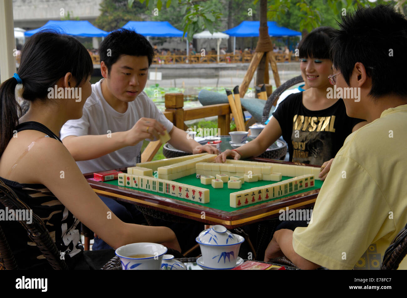 Four young players of the traditional Chinese board game Mah Jonng in the Culture Park of Chengdu Stock Photo