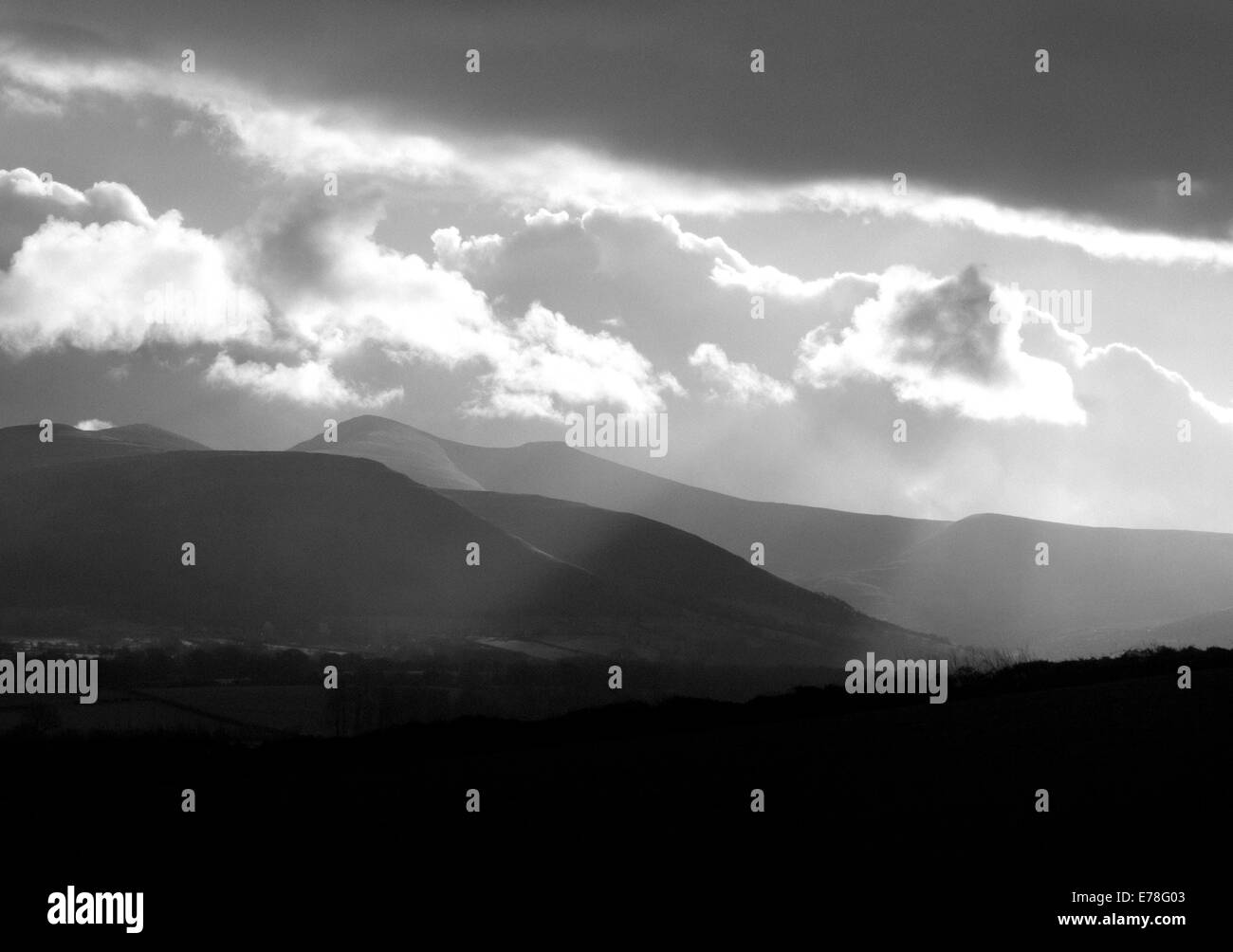 Landscape, sunburst and stormy skies over Brecon Beacon mountains, black and white Stock Photo